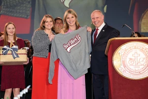 Clancy Callahan, senior journalism major, presents Hager with a C of O sweatshirt.